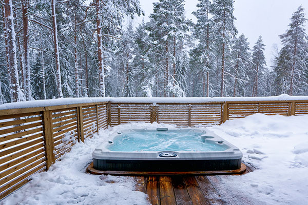 The warm hot tub invites you to relax in the beautiful winter landscape as the snow slowly falls down.